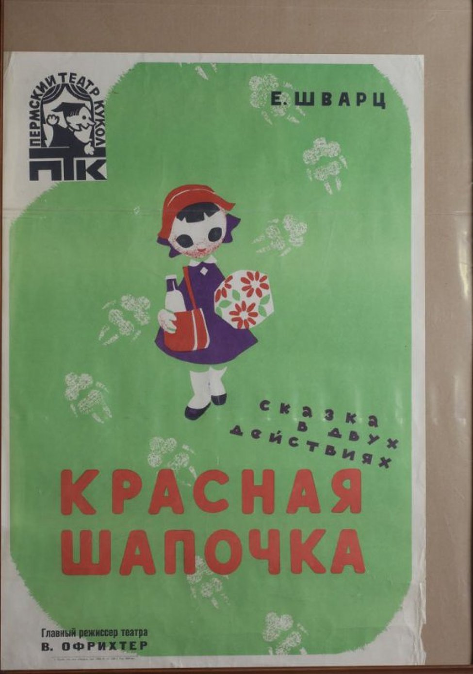 На зеленом фоне - стилизованное изображение девочки в красной шапочке и фиолетовом платье, идущей с сумкой на плече и букетом цветов мимо волчьих следов. Вверху слева - логотип Пермского театра кукол.